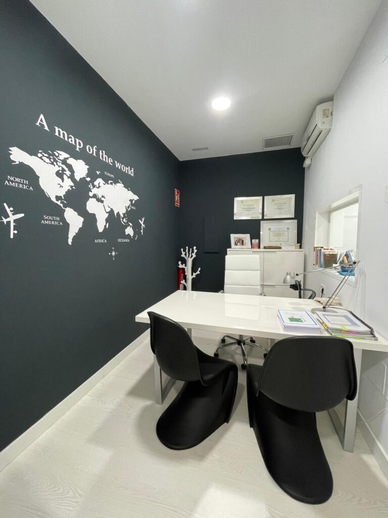 Despacho luminoso con mesa de trabajo y pared oscura del gabinete eduCa